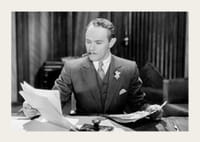 Svartvitt foto av man i kostym med cigarr vid skrivbord-3