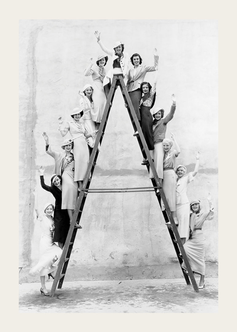 Black and white photograph of women in 1930s clothing on ladder-12