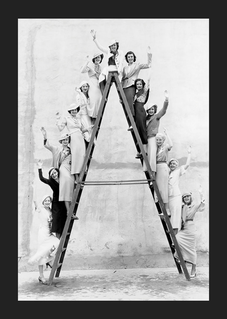 Black and white photograph of women in 1930s clothing on ladder-12