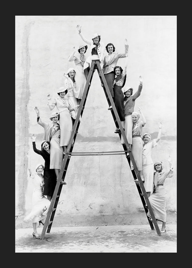 Fotografie alb-negru cu femei îmbrăcate în anii 1930 pe o scară-12