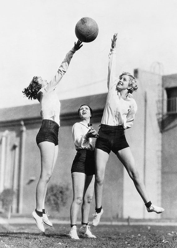 Čiernobiela fotografia troch žien hrajúcich basketbal vonku-12