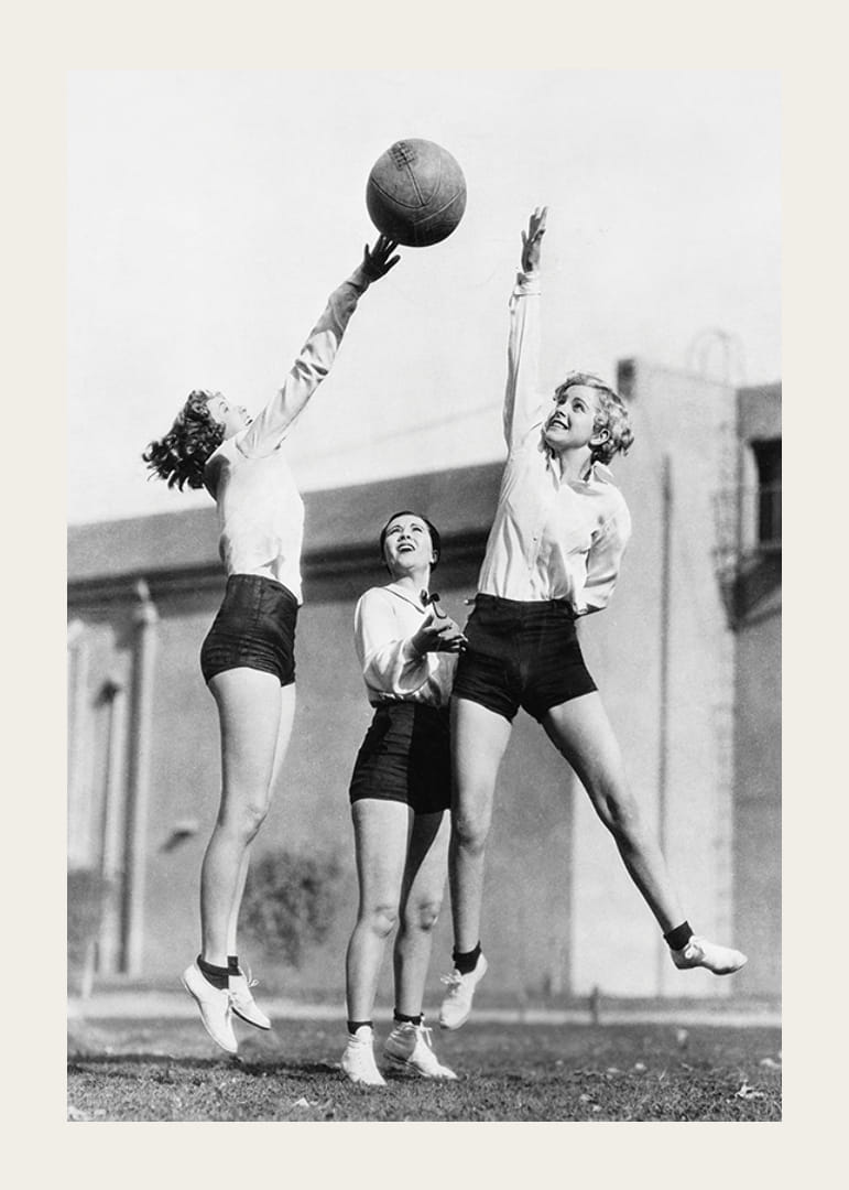 Black and white photograph of three women playing basketball outdoors-12