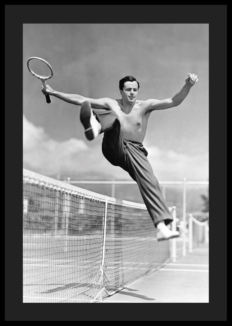 Black and white photo of bare-chested man jumping over tin netting-12