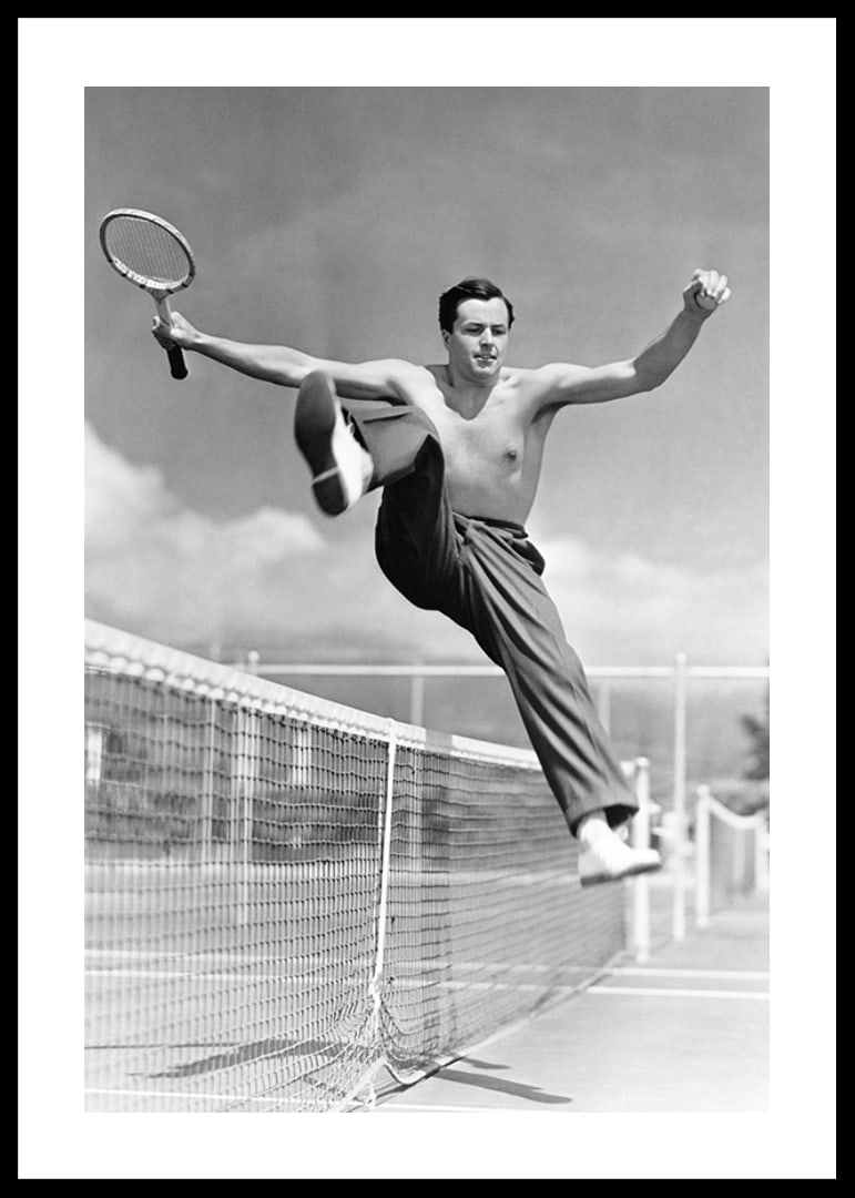 Black and white photo of bare-chested man jumping over tin netting-12