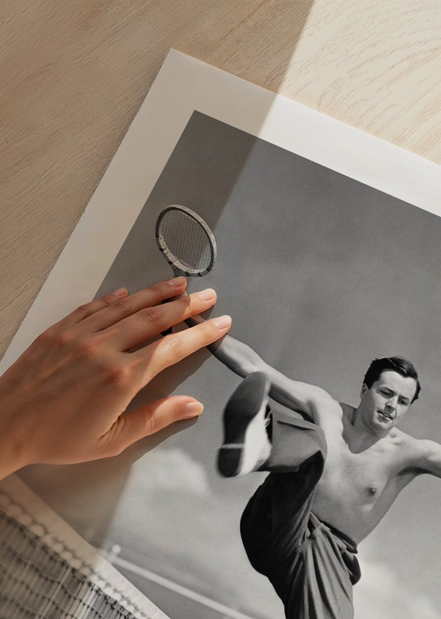 Black and white photo of bare-chested man jumping over tin netting-12