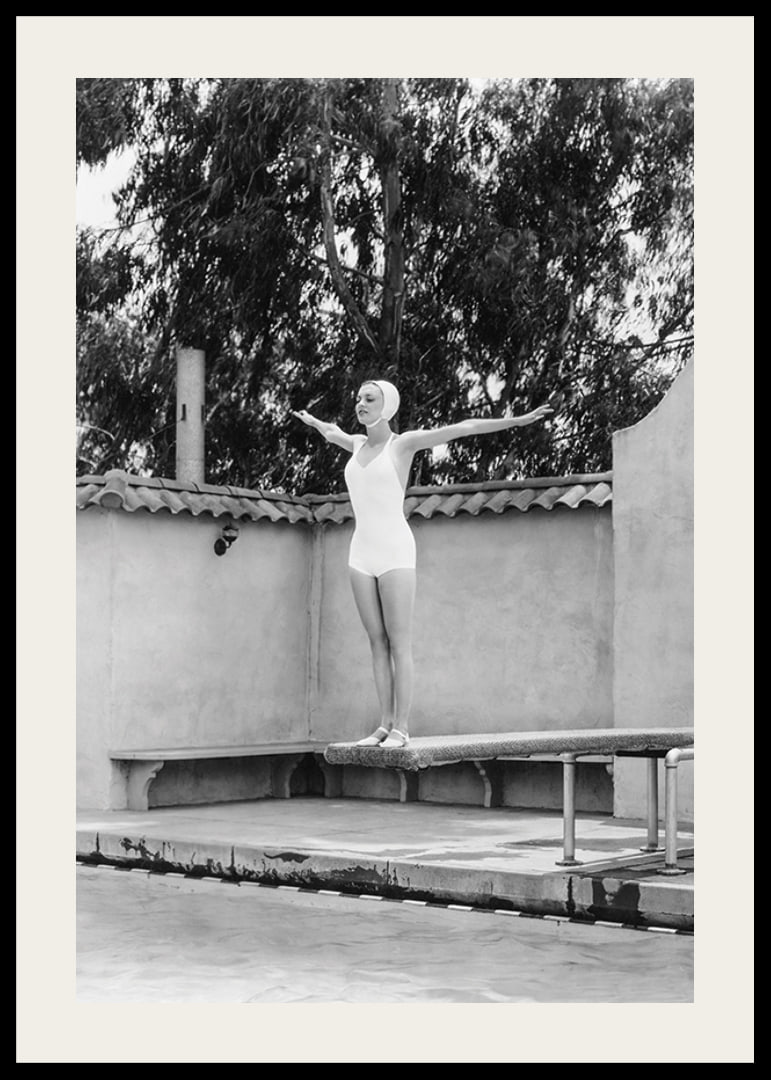 Black and white woman in swimsuit on trampoline at poolside-12