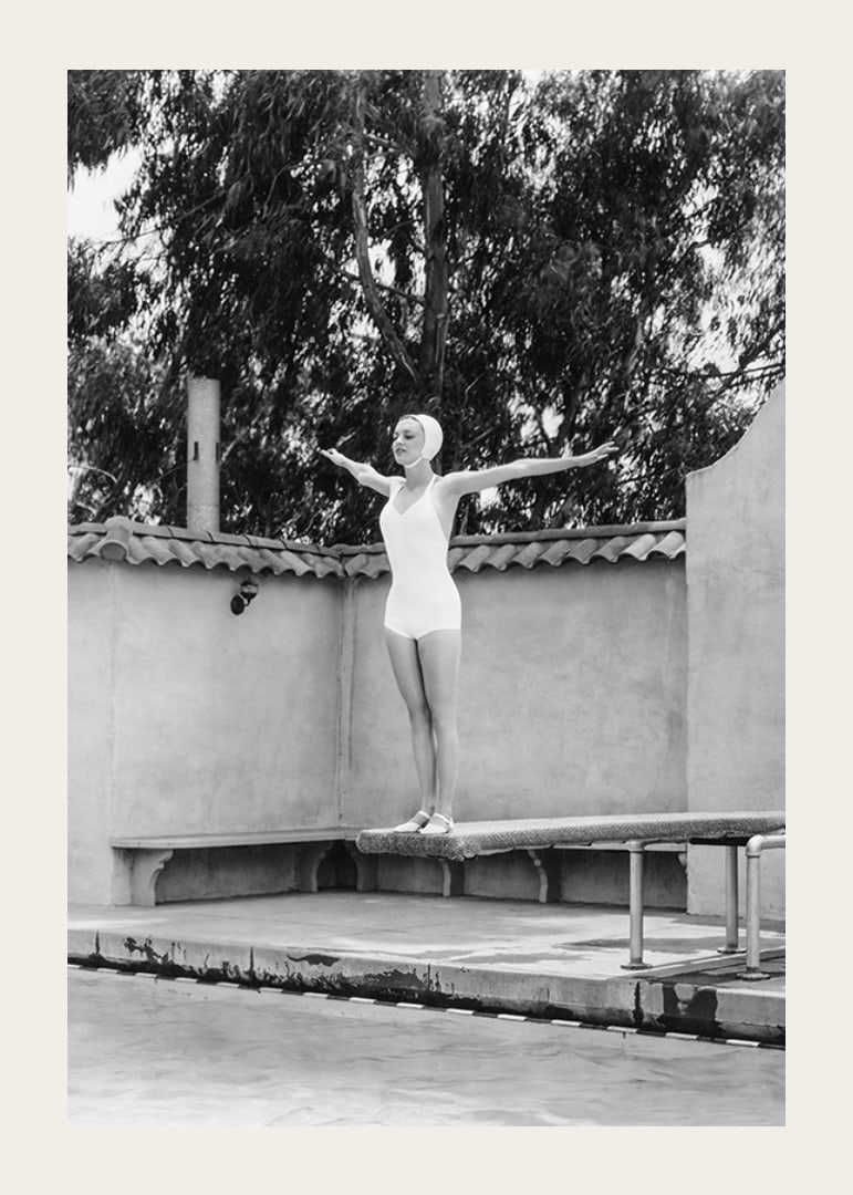 Black and white woman in swimsuit on trampoline at poolside-12