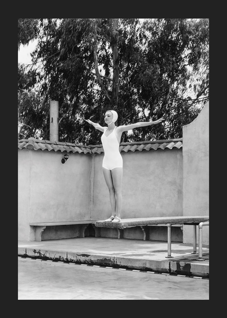 Black and white woman in swimsuit on trampoline at poolside-12