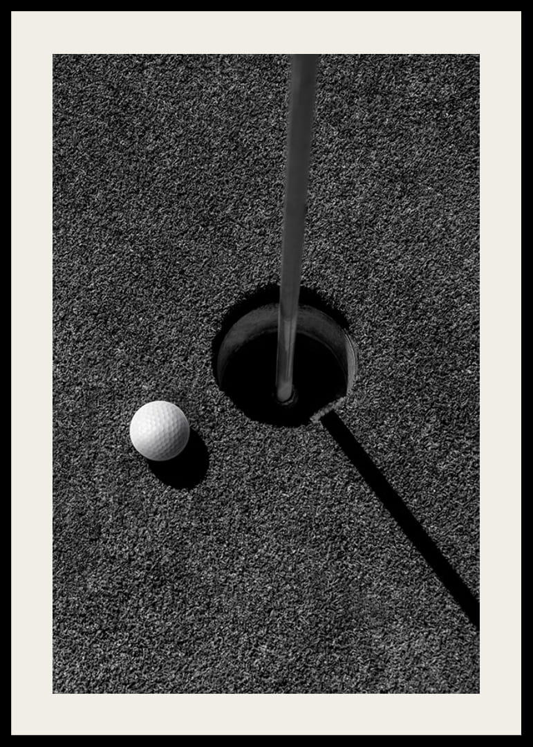 Primo piano in bianco e nero di una pallina da golf accanto alla buca con l'asta della bandiera-12