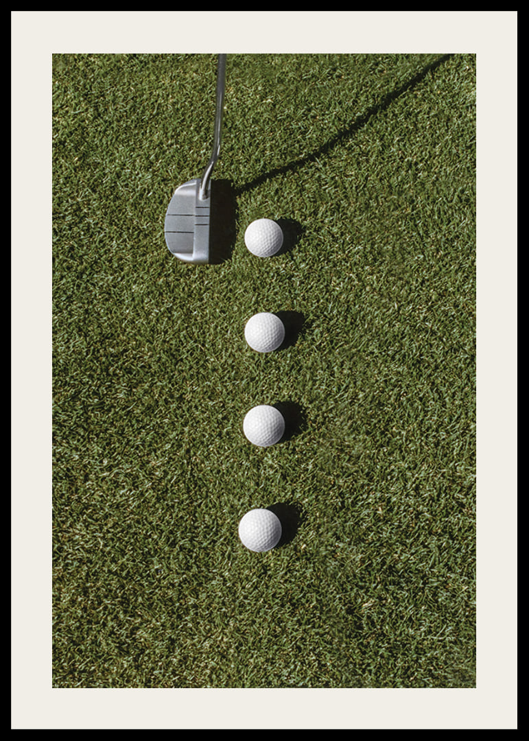 Golf club and four white golf balls on green lawn-12