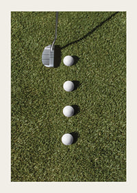 Golf club and four white golf balls on green lawn-3