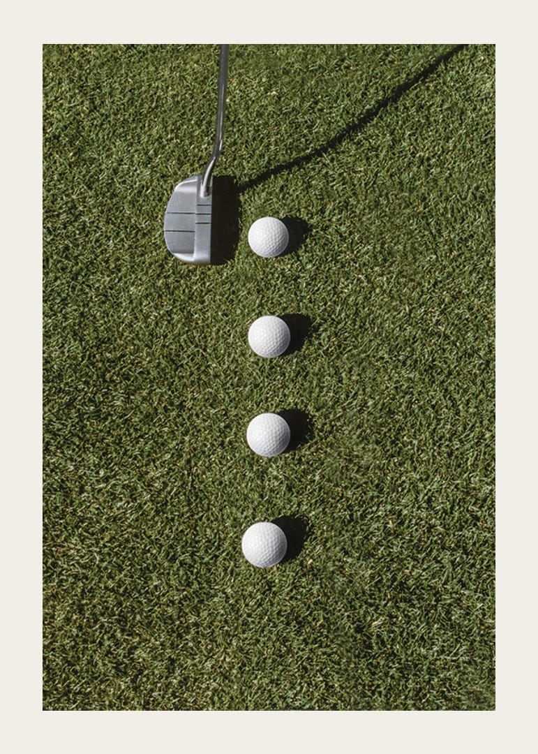 Club de golf et quatre balles de golf blanches sur une pelouse verte-12