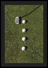Golf club and four white golf balls on green lawn-4