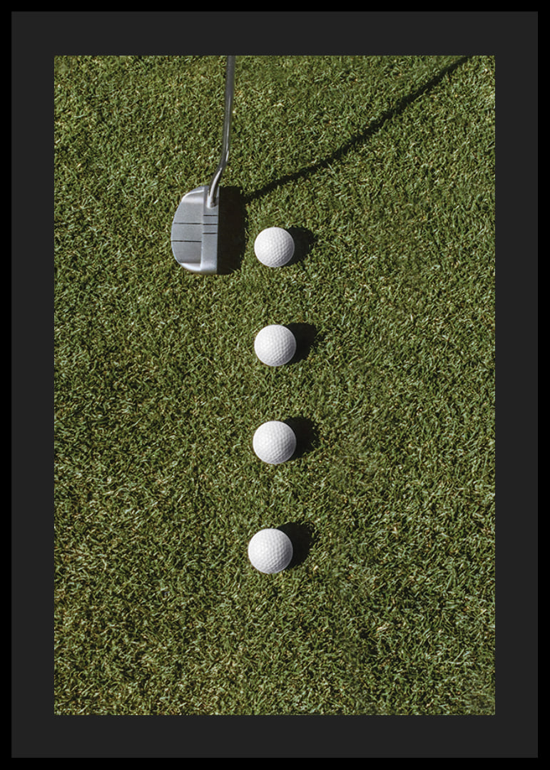 Golf club and four white golf balls on green lawn-12