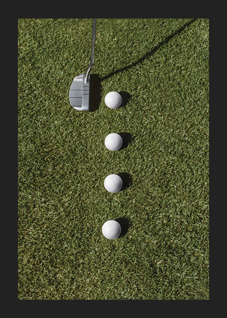 Club de golf et quatre balles de golf blanches sur une pelouse verte-12