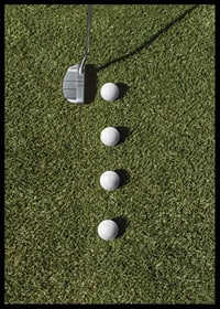 Golf club and four white golf balls on green lawn-6