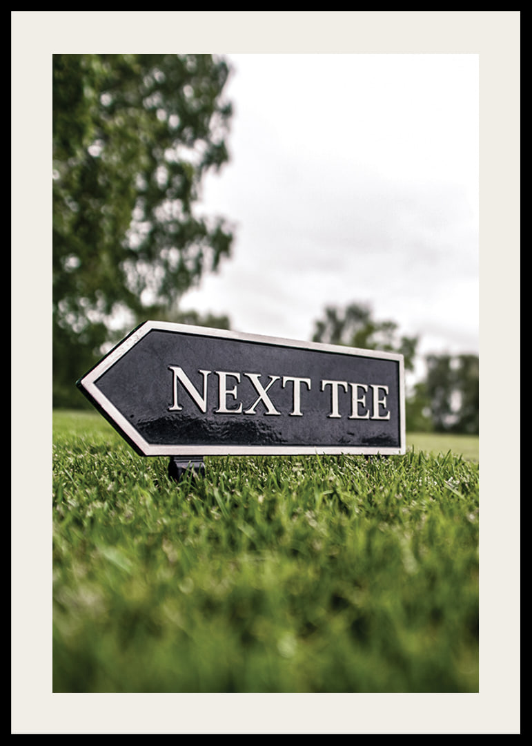 Photographic sign on golf course with the text Next Tee-12