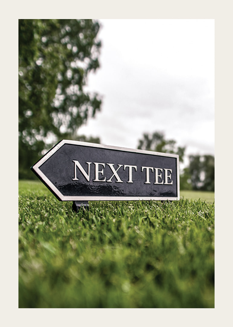 Photographic sign on golf course with the text Next Tee-12