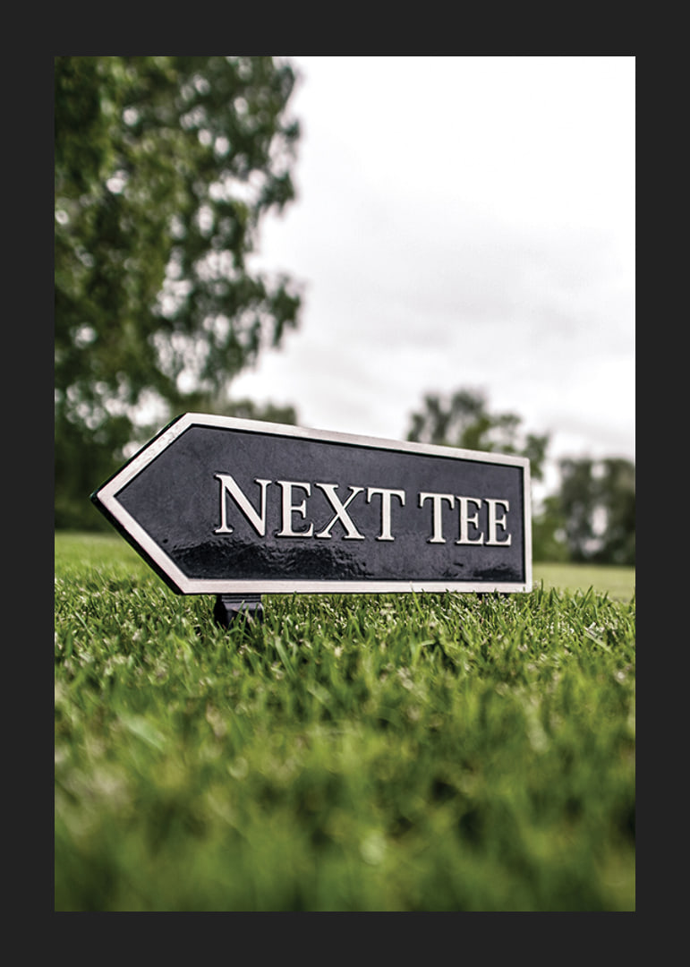 Photographic sign on golf course with the text Next Tee-12