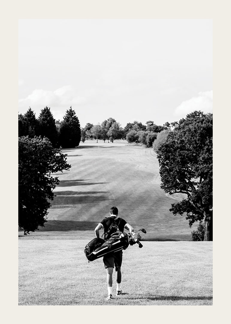 Golfer with bag against fairway in black and white landscape-12