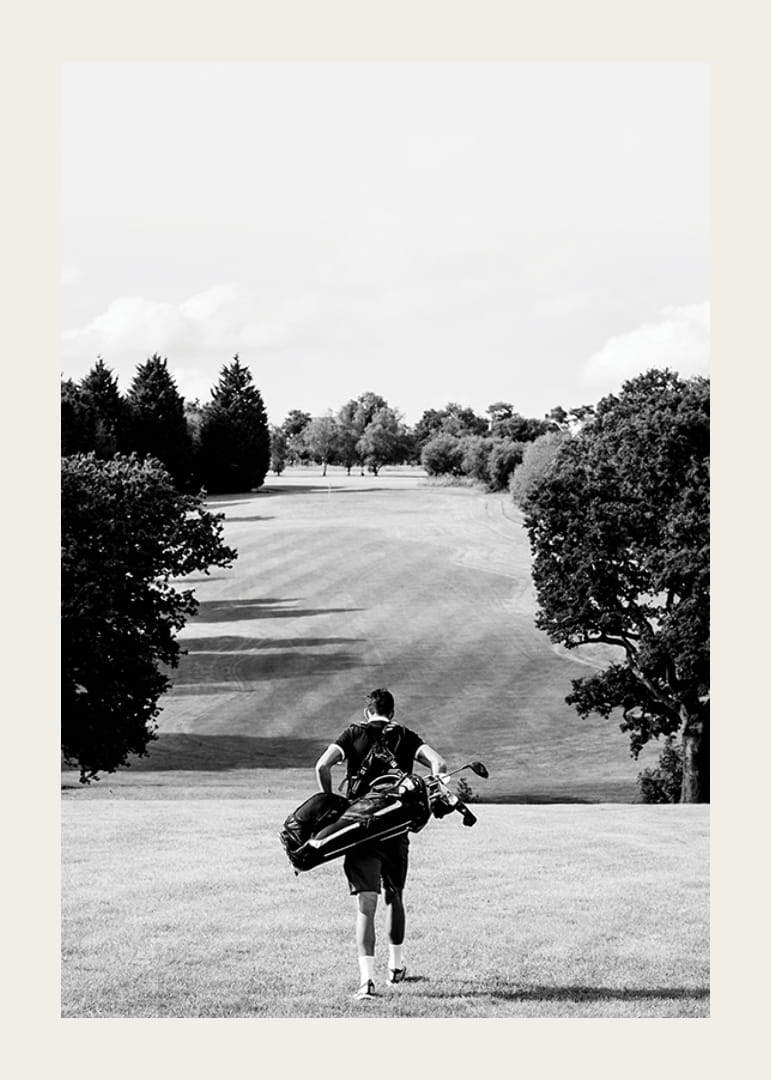 Golfer mit Tasche gegen Fairway in schwarz-weißer Landschaft-12