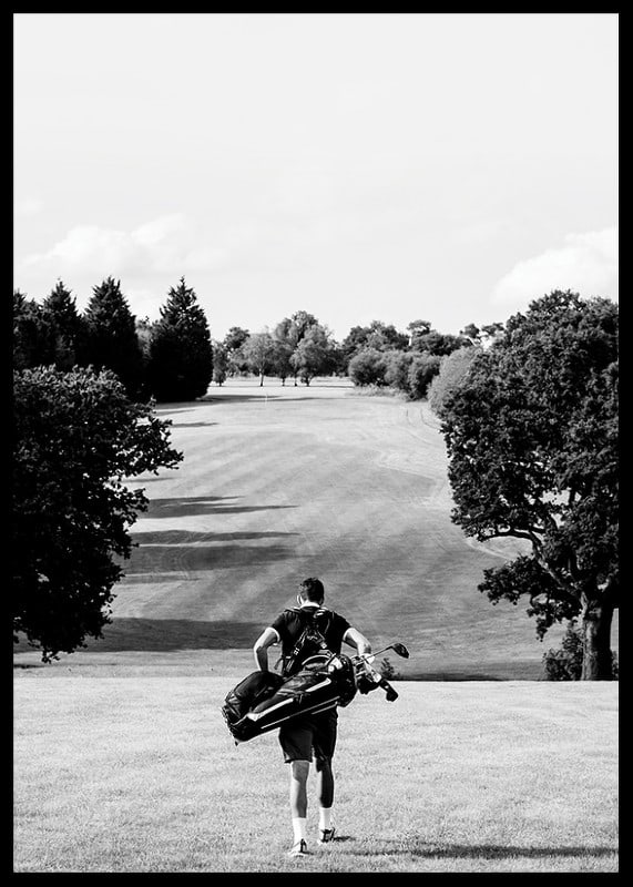 Golfer with bag against fairway in black and white landscape-12