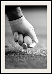 Svart-hvitt nærbilde av hånd med golfhanske som plasserer ballen på tee-2