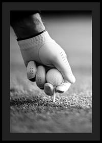 Svart-hvitt nærbilde av hånd med golfhanske som plasserer ballen på tee-4