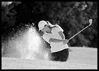 Black and white close-up of golfer in bunker shot, sand is smoking-6
