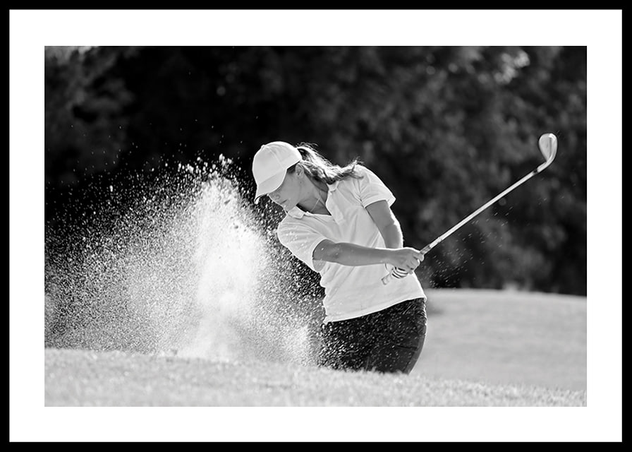 Black and white close-up of golfer in bunker shot, sand is smoking-12