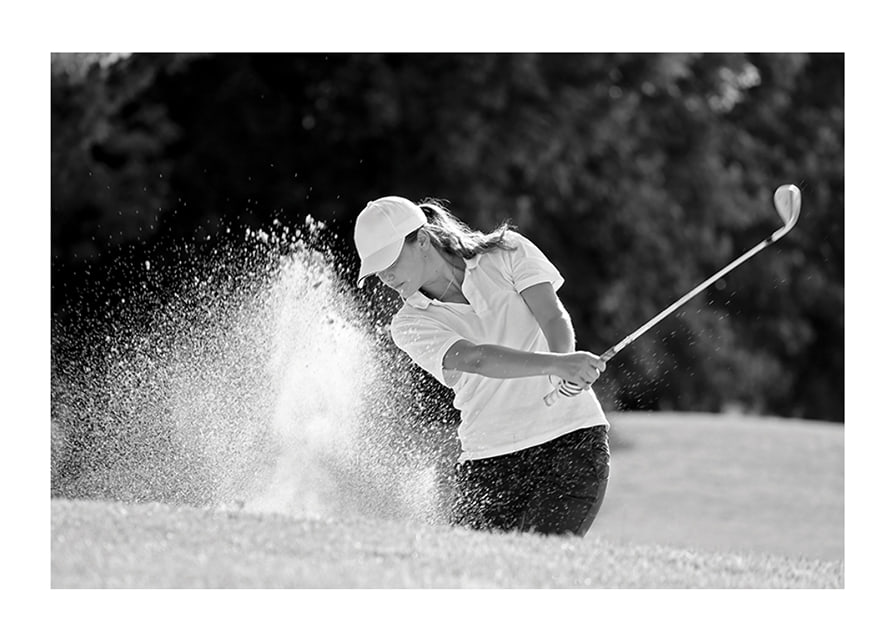 Black and white close-up of golfer in bunker shot, sand is smoking-12