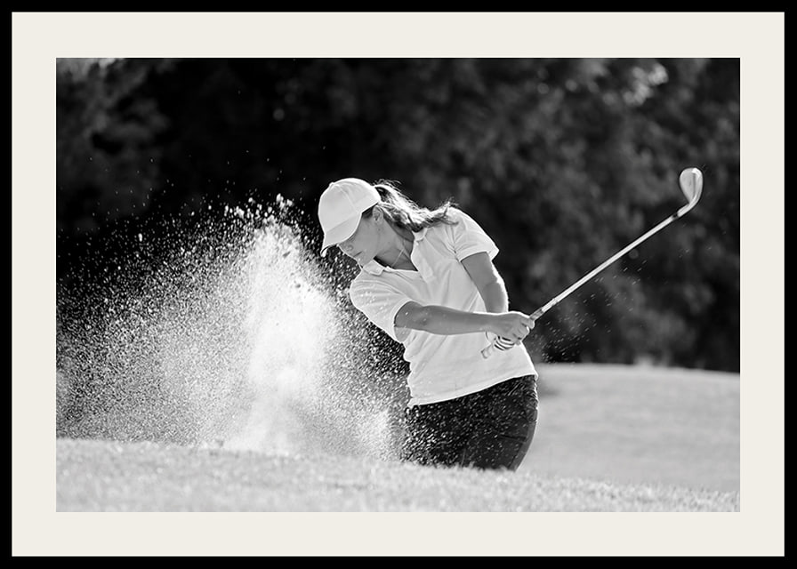 Black and white close-up of golfer in bunker shot, sand is smoking-12