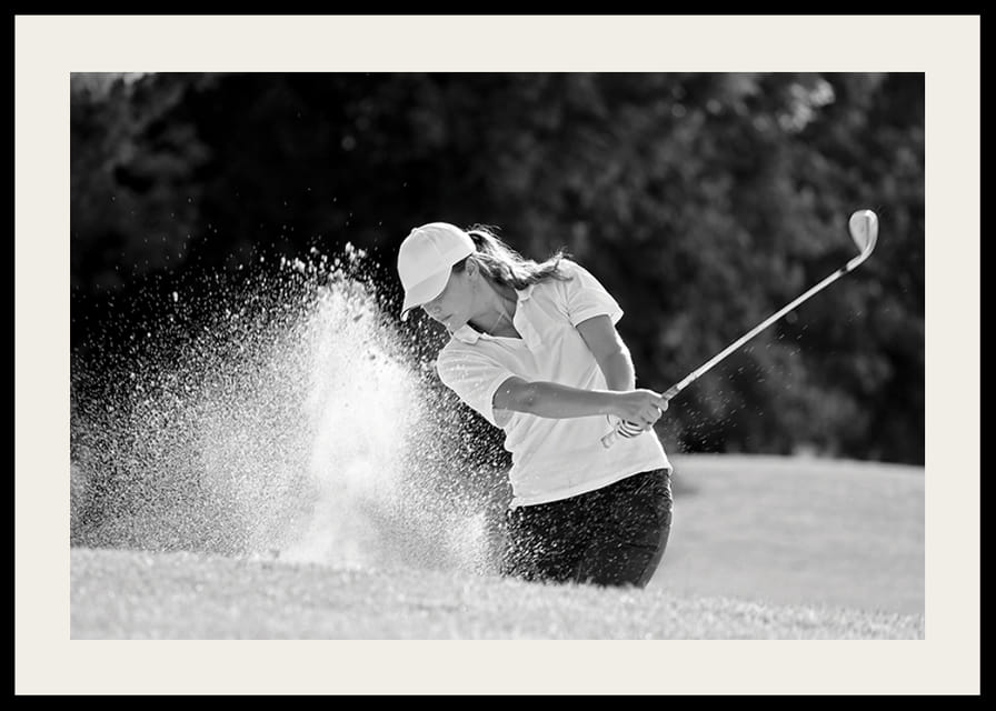Sort-hvid nærbillede af golfspiller i bunkerslag, sandet ryger-12