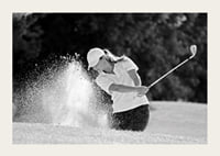 Black and white close-up of golfer in bunker shot, sand is smoking-3