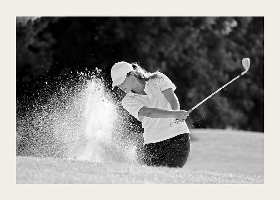 Sort-hvid nærbillede af golfspiller i bunkerslag, sandet ryger-12