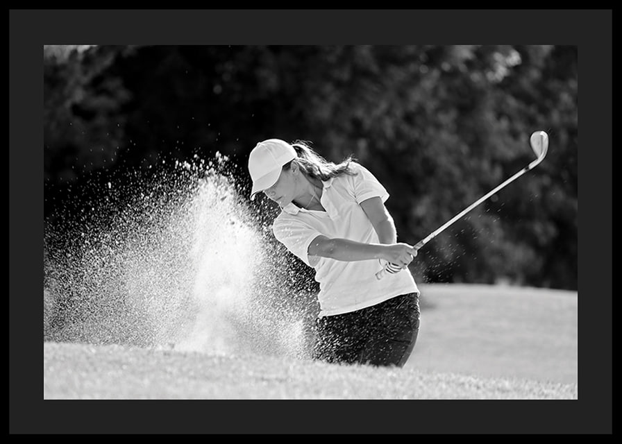 Black and white close-up of golfer in bunker shot, sand is smoking-12