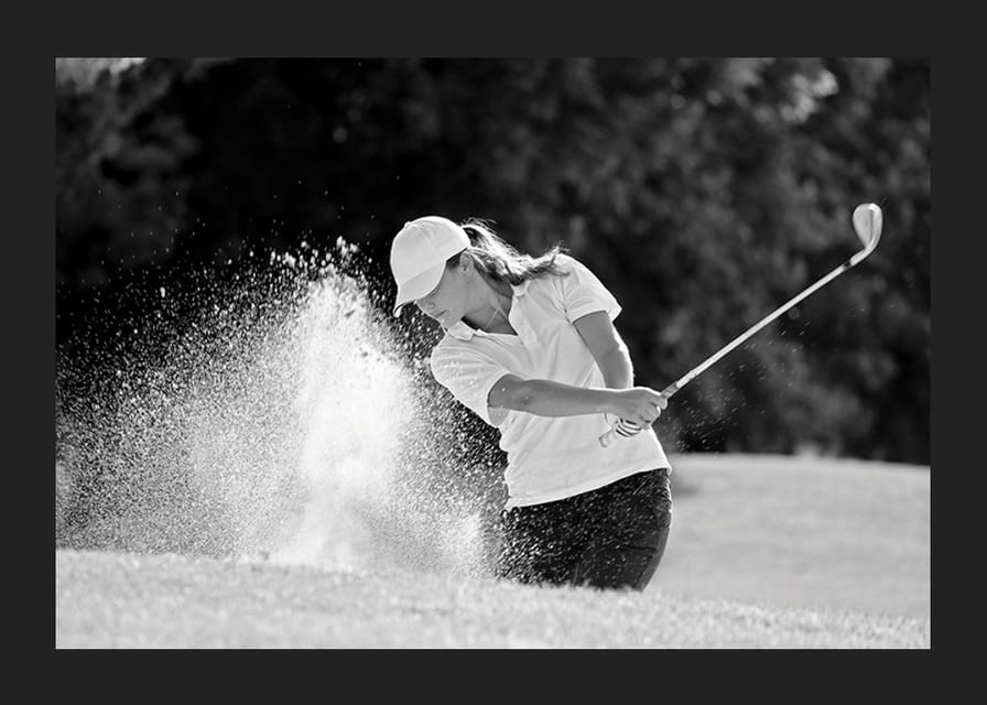 Sort-hvid nærbillede af golfspiller i bunkerslag, sandet ryger-12