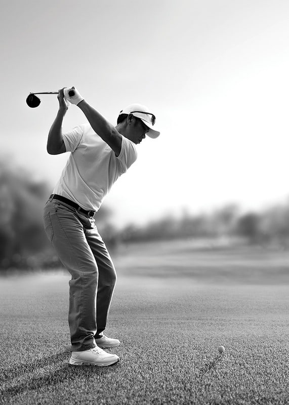 Black and white golfer in line with driver on fairway-12