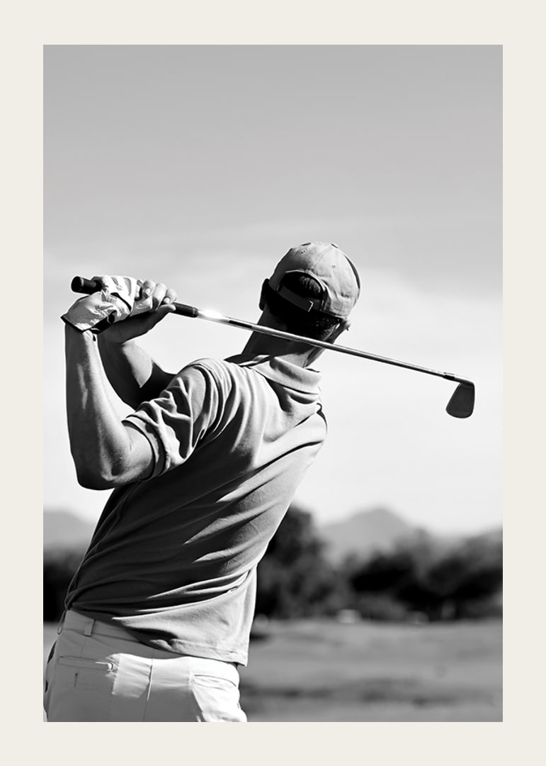 Black and white golfer swinging with club against bright sky-12