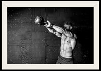 Black and white close-up of man exercising with kettlebell against raw concrete wall-4