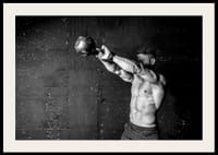 Gros plan noir et blanc d'un homme faisant de l'exercice avec une kettlebell contre un mur en béton brut-4