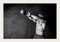 Gros plan noir et blanc d'un homme faisant de l'exercice avec une kettlebell contre un mur en béton brut-5