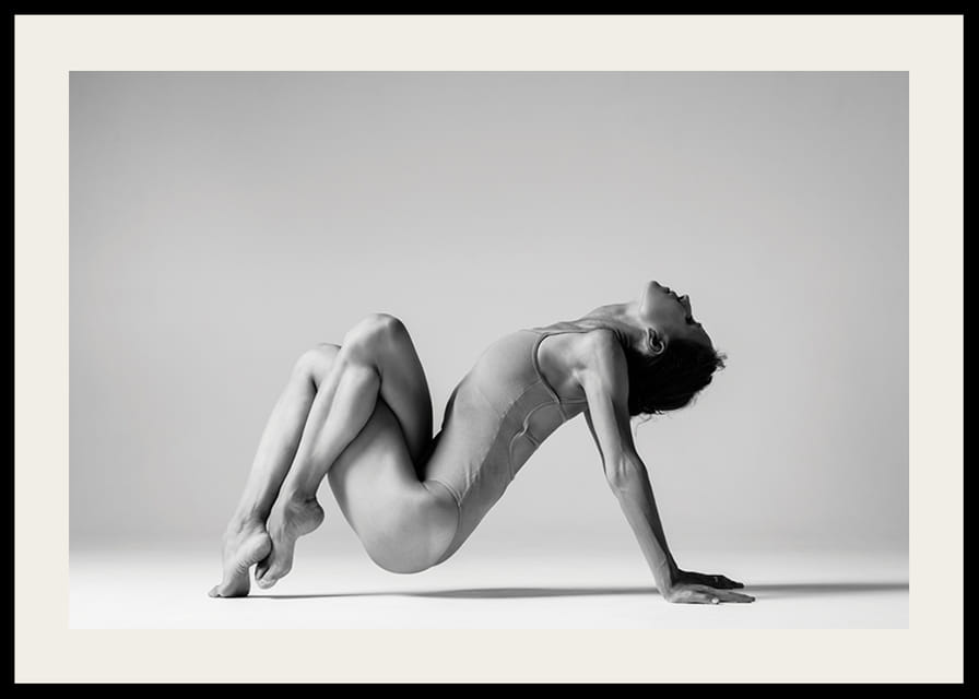 Czarno-białe zdjęcie przedstawiające kobietę w pozycji jogi na jasnym tle-12