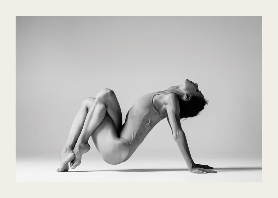 Czarno-białe zdjęcie przedstawiające kobietę w pozycji jogi na jasnym tle-12