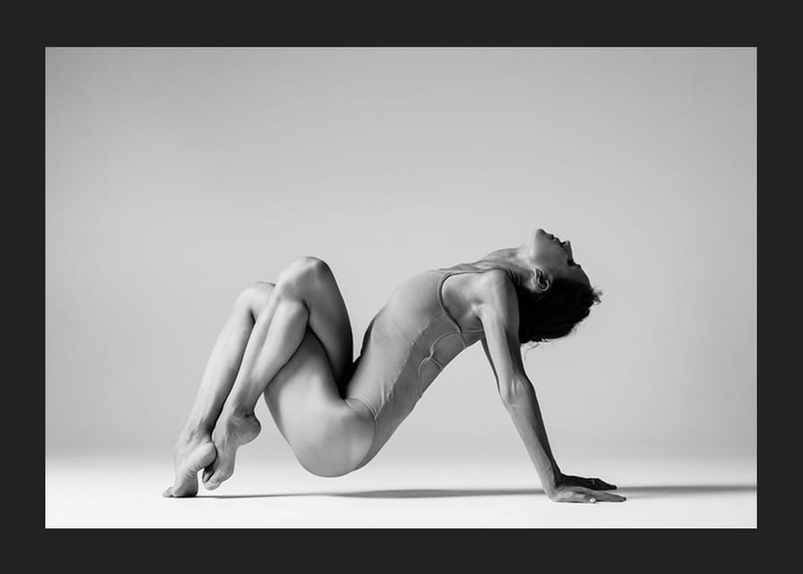 Czarno-białe zdjęcie przedstawiające kobietę w pozycji jogi na jasnym tle-12