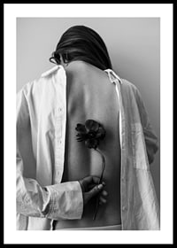 Black and white photograph of woman with flower behind her back-0