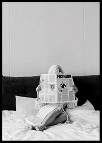 Black and white photo of woman in bathrobe reading newspaper in bed-6