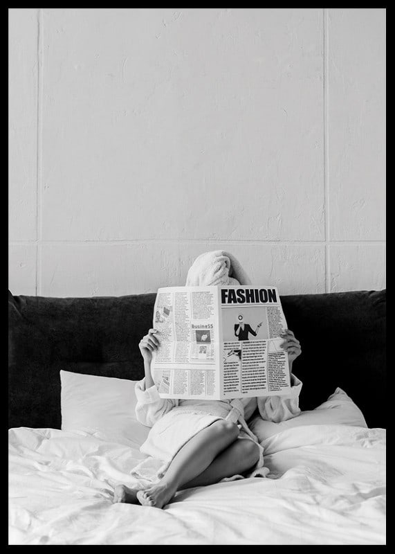 Black and white photo of woman in bathrobe reading newspaper in bed-12