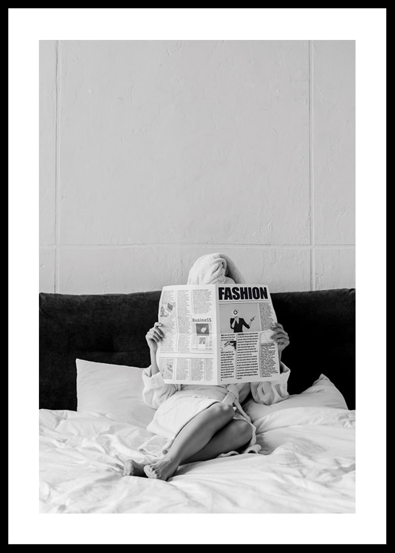 Black and white photo of woman in bathrobe reading newspaper in bed-12