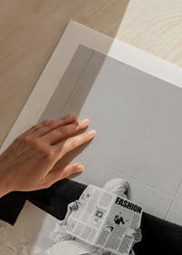 Black and white photo of woman in bathrobe reading newspaper in bed-9